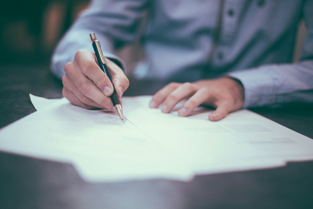 Profissional assinando documentos financeiros